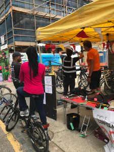 A group of people and bikes around a festival stand