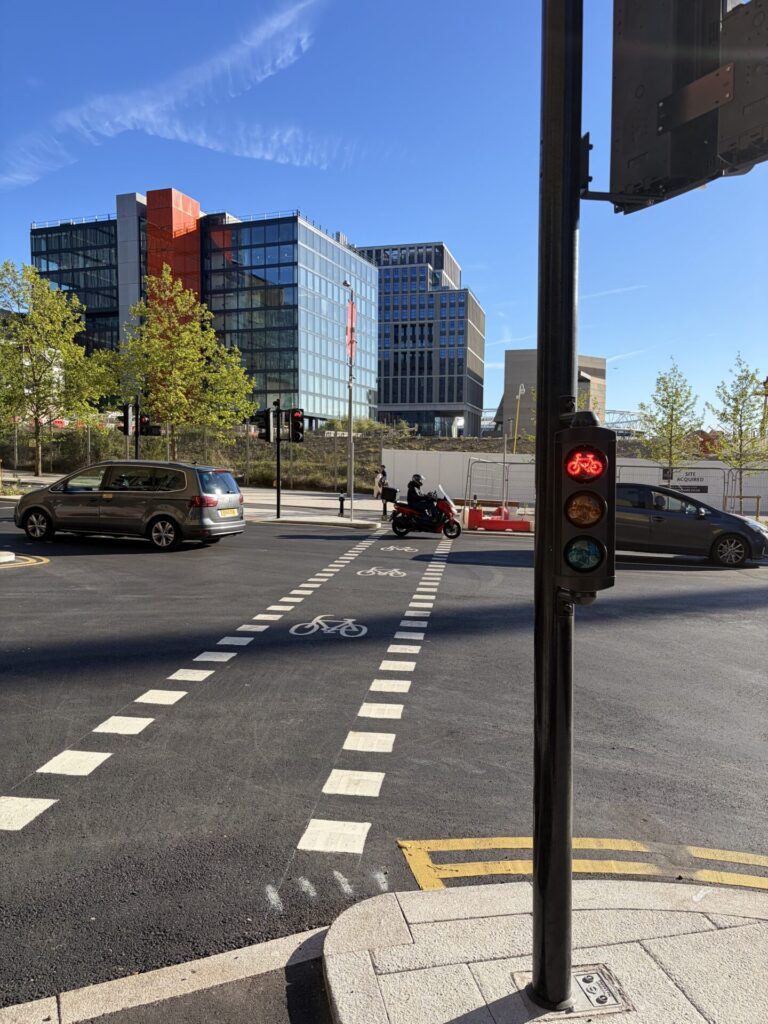 One-way signalised cycle crossing marked with elephants' footprints (white squares) across a large road.