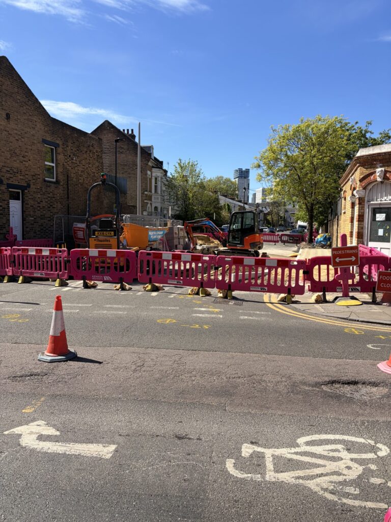 Plastic fencing surrounding a side road as it is reconstructed.