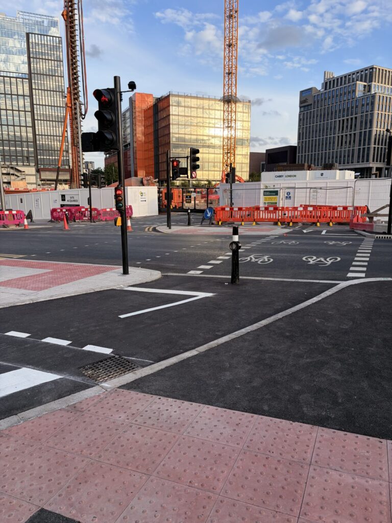 Two-way cycle track signalised crossing of a road with an adjacent signalised pedestrian crossing, and a zebra crossing of the cycle track.